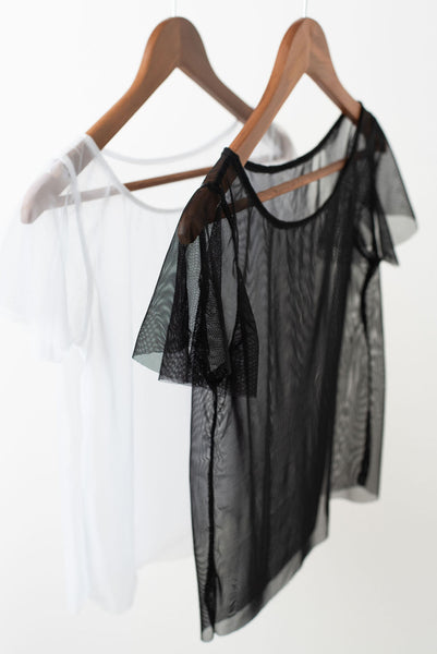 One white sheer mesh short sleeved t-shirt and one black, both on wooden hangers.